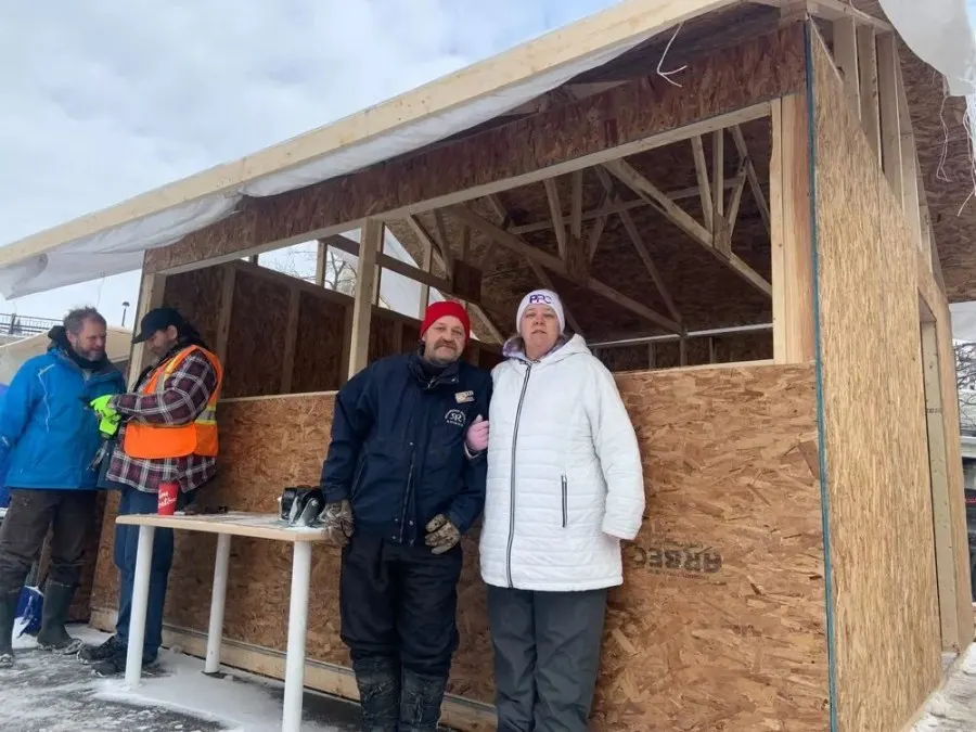 Bertrand Brunet and Tina Trealout stand outside the makeshift wooden “community kitchen” near Confederation Park. JON WILLING/POSTMEDIA