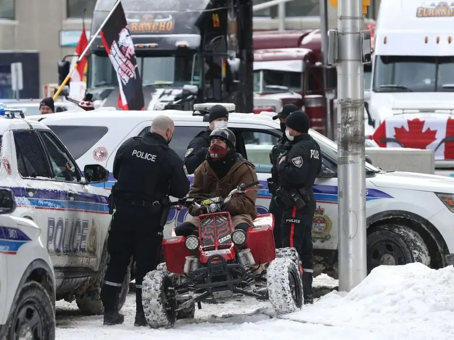 Anti-vaccine mandate protesters and truckers protesting their eighth day in Ottawa Friday. A man with a  4 wheeler gets asked questions by the Ottawa Police on Kent Street in Ottawa.