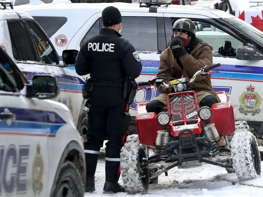 Anti-vaccine mandate protesters and truckers protesting their eighth day in Ottawa Friday. A man with a  4 wheeler gets asked questions by the Ottawa Police on Kent Street.