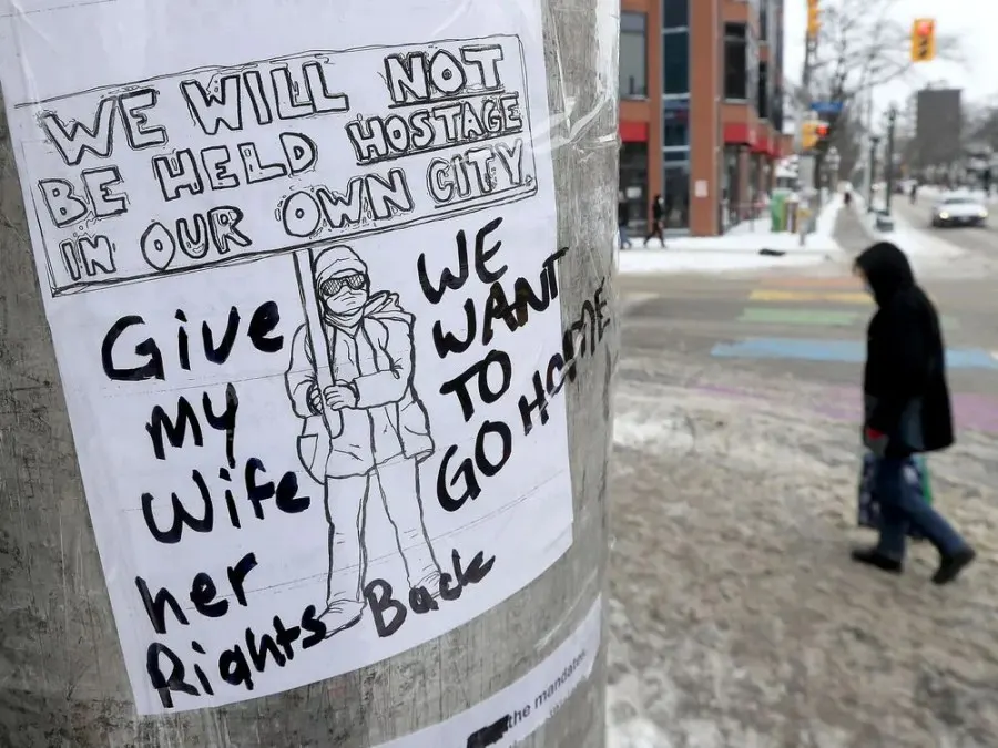 A woman walks past a sign on Bank Street in Ottawa Friday. The sign said 