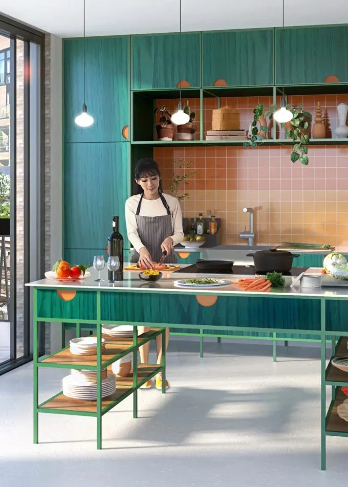 Woman cutting vegetables in contemporary green kitchen