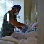 ICU nurse Derek McKenzie helps treat a patient with severe COVID-19 at King’s Daughters Medical Center in Brookhaven, Mississippi.
